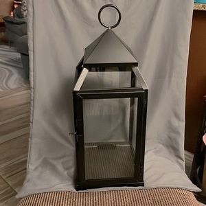 Black lantern with glass walls. About 18” tall, 6 1/2” wide on all four corners.